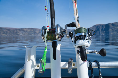 Fishing boat with fishing rod and reels off mountains in the Norwegian fjord landscape. Crystal clear water in Scandinaviaの写真素材