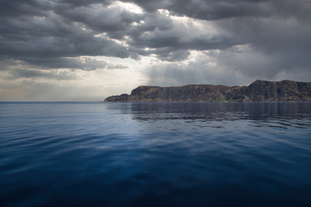 View from the sea to the West Cape in Norway under a dramatic sky. Waves in the foreground, rocks in the background. Westernmost point of the Euの写真素材