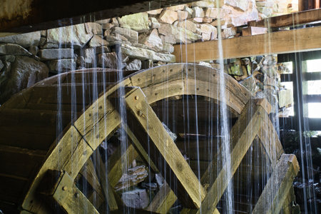 Old wooden waterwheel splashed by falling water. Picture from a watermill in Sweden by a stream.の写真素材
