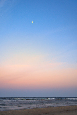 Moon in the sky in front of the beach on the island of Usedom on the Baltic Sea. Landscape shot of the coastの写真素材