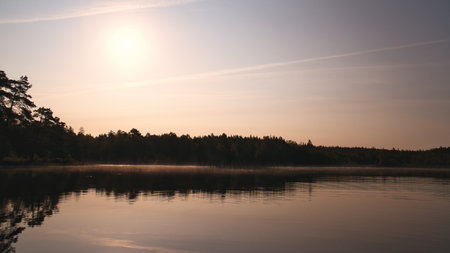 Lake in Sweden, mirror-smooth water with romantic light and trees on the shore. Scandinavian natureの写真素材