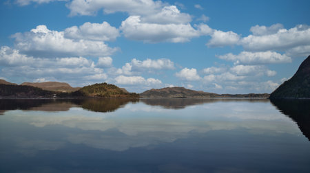 Fjord with view of mountains and fjord landscape in Norway. Blue sky, white clouds, calm...