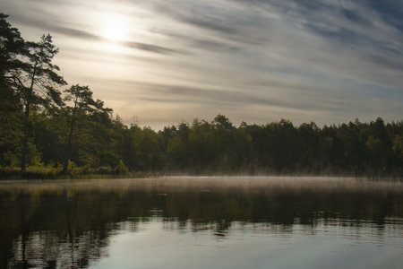 Sunrise with fog forming over a lake in Sweden, at dawn. Romantic silence, in the Scandinavian natureの写真素材