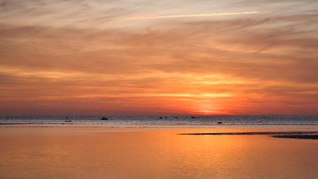 Warm sunset over calm ocean with golden reflection and gentle waves, peaceful mood and natural color...