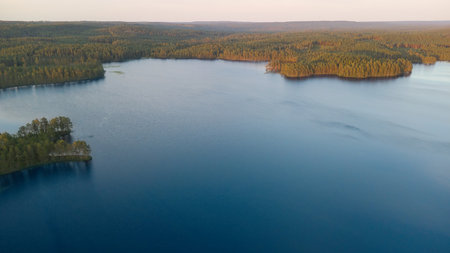 Aerial view of a deep blue lake with forested surroundings, natural beauty, tranquility and ecological diversity in a remote natural paradise.の写真素材