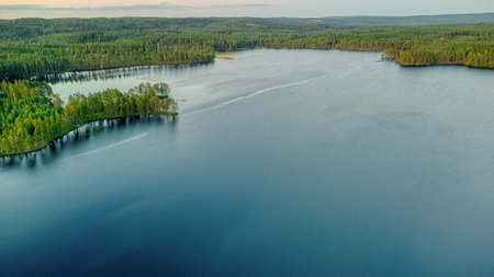 Aerial view of a deep blue lake with forested surroundings, natural beauty, tranquility and ecological diversity in a remote natural paradise.の写真素材