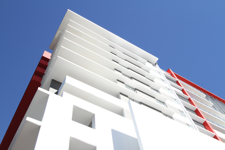 Modern Residential Apartment Block. Mostly white with red highlight, located in tropical Queenslandの写真素材