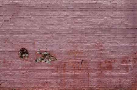 An old brick wall painted pink and decayingの写真素材