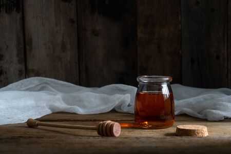 honey cake. jar of honey. hand with a spoon for honey. honey drips from a spoonの写真素材