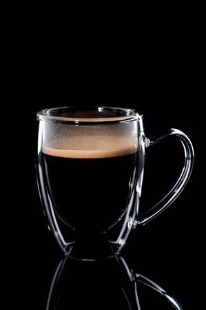 black coffee in a glass transparent cup on a black background.の写真素材