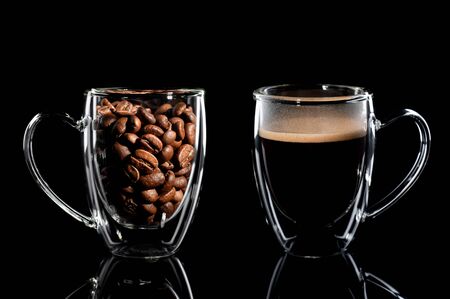 composition of two cups with coffee on a black background. left side cup with coffee bean side view, right side cup with finished coffee side view. Black background.の写真素材