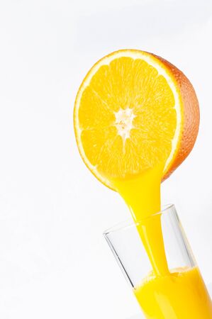  Fresh orange juice is poured from half an orange into a transparent glass. place for inscription.の写真素材