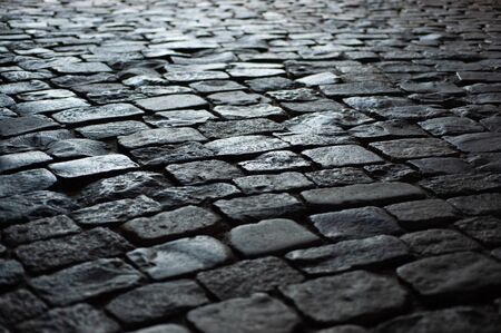 background texture old road from large old stones leaves in perspective.
