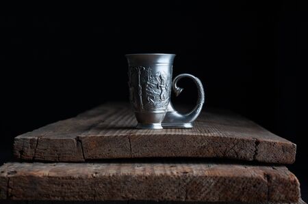 antique glassware cup stands on a wooden background.の写真素材