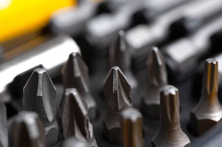 interchangeable screwdriver bits in a plastic box close-up macro isolated on a white background.の写真素材