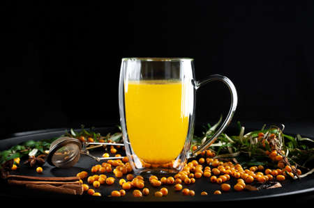 sandthorn tea with spices on a black background. High quality photo