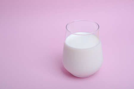 glass with milk on a pink background. High quality photo