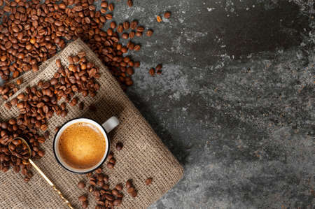 a cup of coffee with a beautiful froth stands on a fabric against a concrete background, coffee...