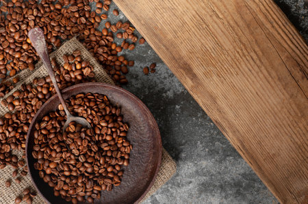 roasted coffee beans in an old vintage frying pan top shot. copy spaceの写真素材
