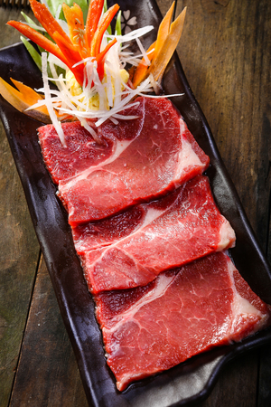 Fresh beef slice on wooden background uncookedの写真素材