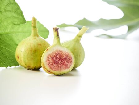 Fresh fruit figs sliced placed with leaves on white background. Fruit for health. top view, close upの写真素材