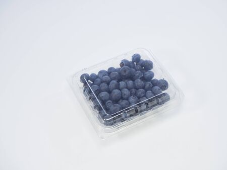 Freshly blueberry in a plastic box packed on a white background. space for textの写真素材
