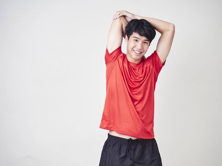Studio portrait of young man exercising before sport training isolated over a white background