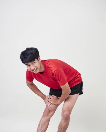Studio portrait of young man exercising before sport training isolated over a white backgroundの写真素材