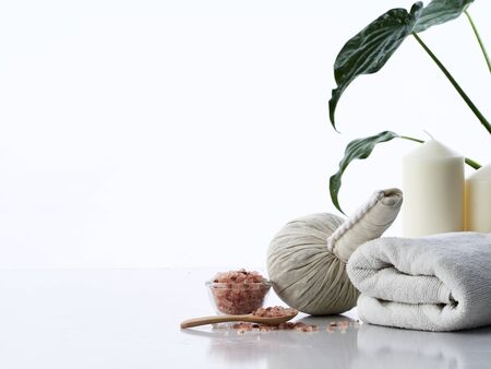 Spa massage concept, herbal compress ball, cream, flower soap, scented candle and Himalayan pink...