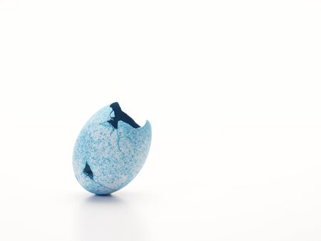 Easter egg painted with cracked open blue on white background.の写真素材