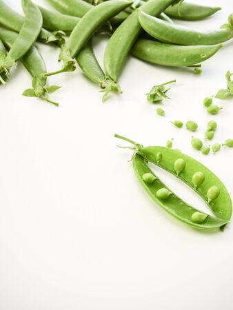 Fresh green peas with pods isolated on white background. Vegetarian food concept. Top view, copy space.の写真素材