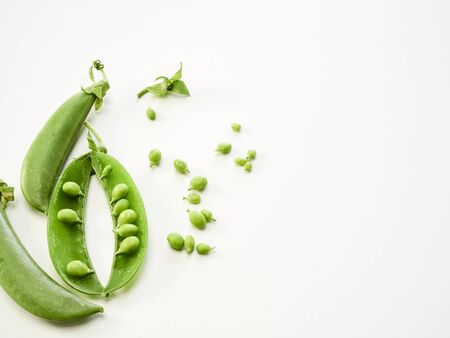 Fresh green peas with pods isolated on white background. Vegetarian food concept. Top view, copy space.の写真素材