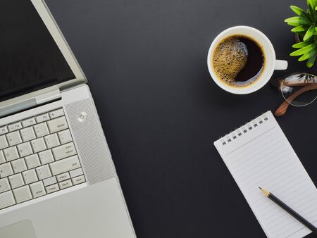 Workspace mockup on office desk with laptop, notebook, eyeglasses and coffee cup. Top viewの写真素材