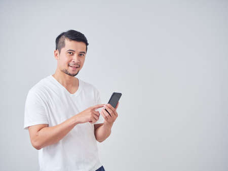 Portrait of young man with shopping bags while standing on white background.の写真素材