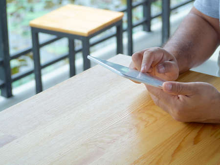 Close-up of a man using tablet in outdoor park.