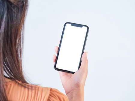 close-up of woman hand holding smartphone with blank screen, mock-up on white background