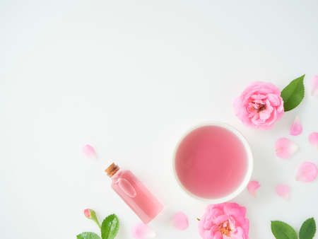 Spa set. Bottles of essential oil, roses and scented candles on white backgroundの写真素材