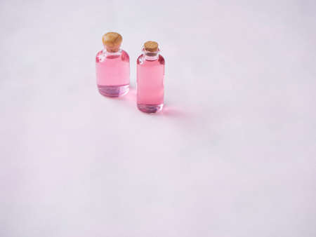 Bottles of essential oil on pink background. Space for textの写真素材