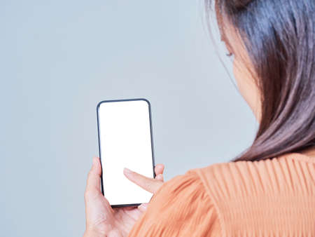 Mock up of the smartphone in hand of girl on gray background