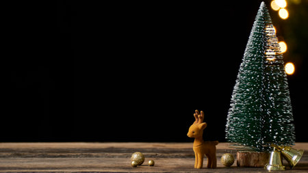 Christmas tree with reindeer on rustic vintage wooden table. Bokeh effect, space for textの写真素材