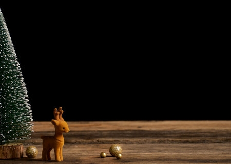 Christmas tree with reindeer on rustic vintage wooden table. Bokeh effect, space for textの写真素材