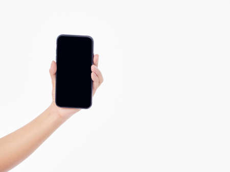 Woman holding mobile phone with blank screen on white background, closeup
