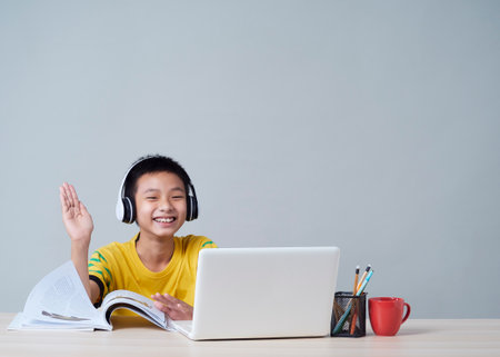 Little boy in headphones studying online using laptop. Social distance during quarantine