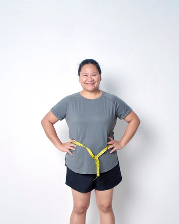 Fat woman measuring waist with tape on white background. Weight loss conceptの写真素材