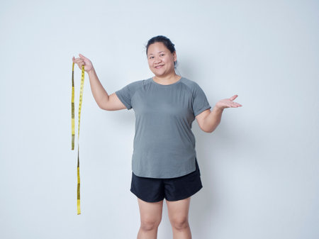 Fat woman with measuring tape on white background. Weight loss conceptの写真素材