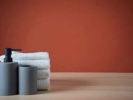 Clean towels and Soap dispenser on wooden table. Space for text