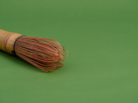 Bamboo whisk on green background. Space for textの写真素材