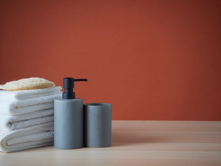 Bathroom set with clean towels, sponges, soap dispenser on wooden table. Space for textの写真素材