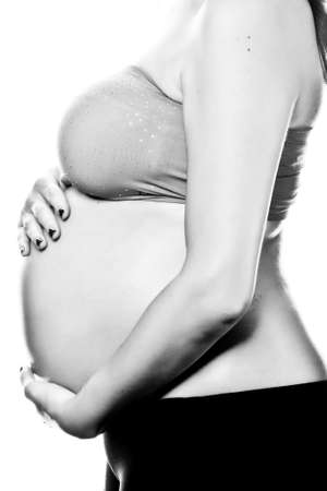 Woman hands on pregnant belly shooting in studioの写真素材