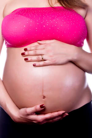 Woman hands on pregnant belly shooting in studioの写真素材